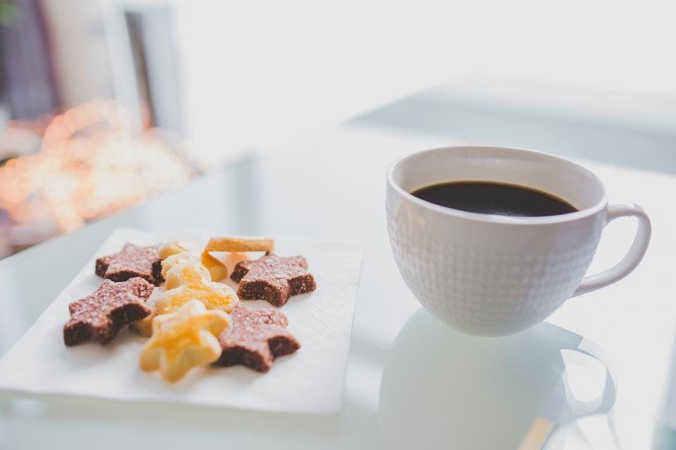 A cup of coffee beside star-shaped cookies